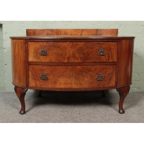 616 - A walnut veneer oval shaped dressing table with quarter veneer top and two drawers