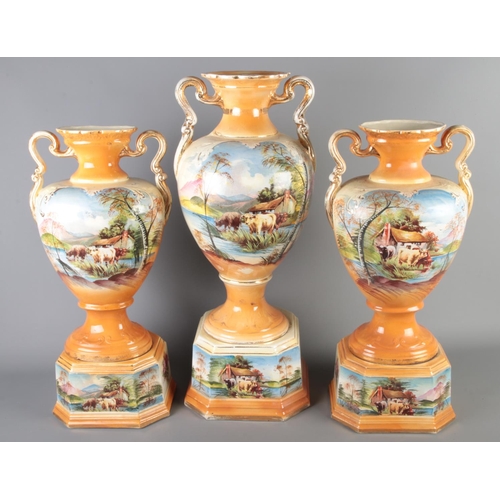 12 - A trio of large Victorian porcelain vases with hand painted and gilt finish 

Largest Hx63cm