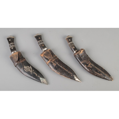 121 - Three Indian Kukri knives with sheaths; one bearing 5th Gurkha Rifles badge. Largest in sheath: 27cm... 