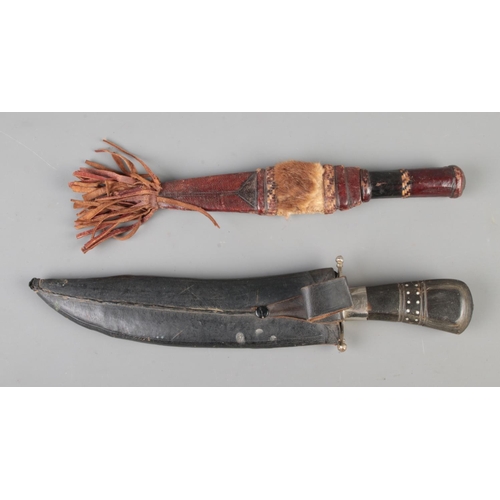 123 - A large Indian Kukri knife in sheath, together with a tribal dagger. CANNOT POST.