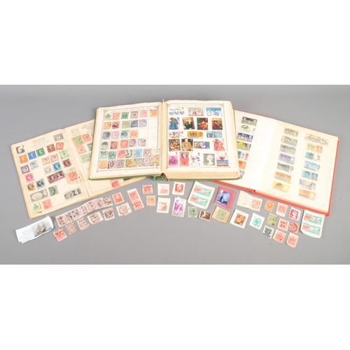 169 - Three partly filled world stamp albums, together with a small collection of loose examples.