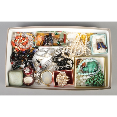 217 - A tray of costume jewellery, containing beaded necklaces, loose gemstones including tiger's eye, but... 