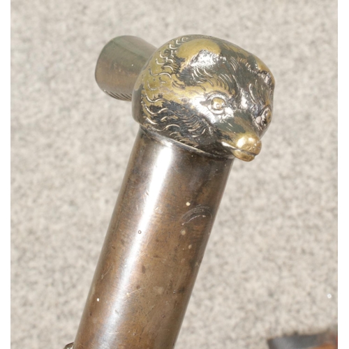 222 - An ebonised walking cane with white metal animal head pommel, along with two riding whips. One by Li... 