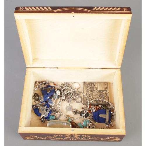 223 - A carved jewellery box containing an assortment of silver and white metal jewellery oddments. To inc... 