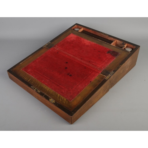 233 - A Victorian walnut writing slope with brass inlaid decoration.