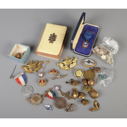 236 - A quantity of mostly military collectables to include Kings Dragoon Guards cap badge, General Post O... 