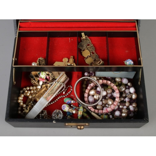 243 - A vintage jewellery box with contents of assorted costume jewellery to include beaded necklaces, bra... 