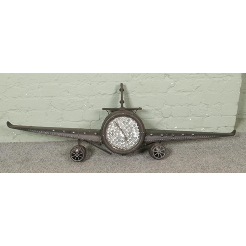 255 - A retro metal aeroplane clock, with altered coin dial. Width of wings: 141cm.