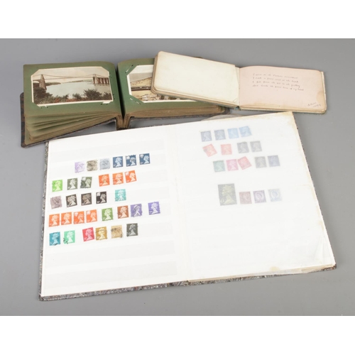 258 - An album of postcards, along with an album of stamps and an autograph album with sketches and inscri... 