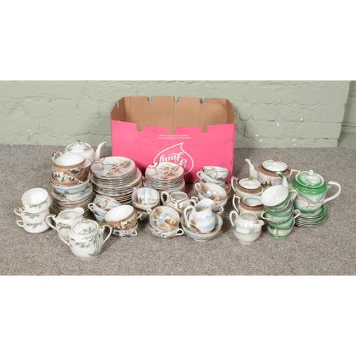 264 - A large collection of oriental style tea sets including geisha cup examples