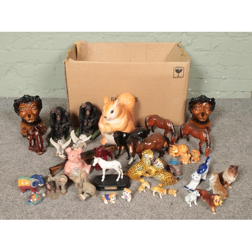 271 - A large collection of animal figurines including horses, Garfield figures, lion money banks, squirre... 