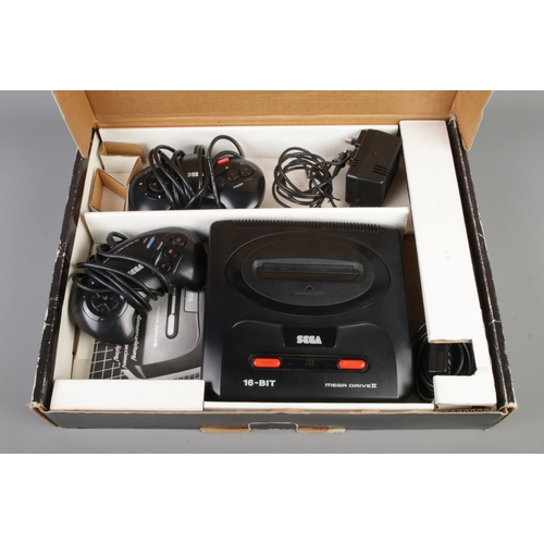 409 - A boxed Sega Mega Drive II, with two control pads, together with a collection of games including Son... 