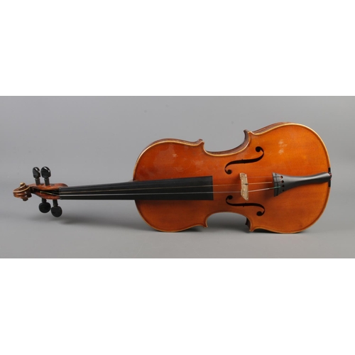 411 - A wooden cased violin with bow. Having two piece 14 inch back.