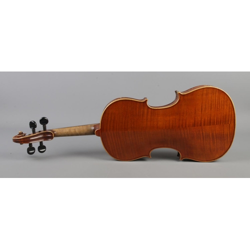 411 - A wooden cased violin with bow. Having two piece 14 inch back.