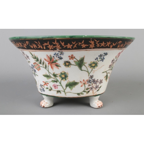 43 - A Wong Lee ceramic centerpiece/planter bowl featuring hand painted floral decoration and raised on p... 