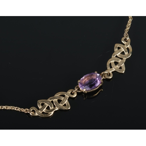 527 - A 9ct gold necklace featuring amethyst stone flanked by Celtic knot design. Total weight 5.03g.