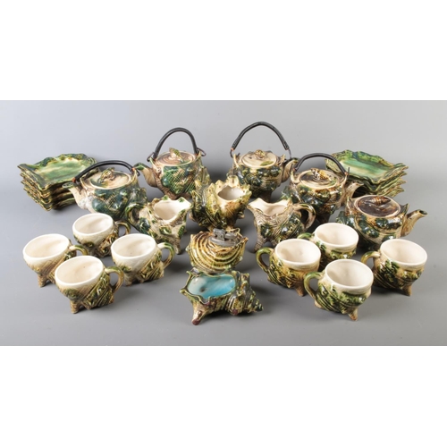 8 - A majolica tea service formed as conch shells to include tea cups, table lighter, preserve pots, etc... 