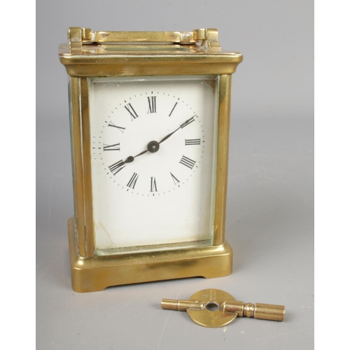 603 - A French brass carriage clock with bevelled edge glass and key