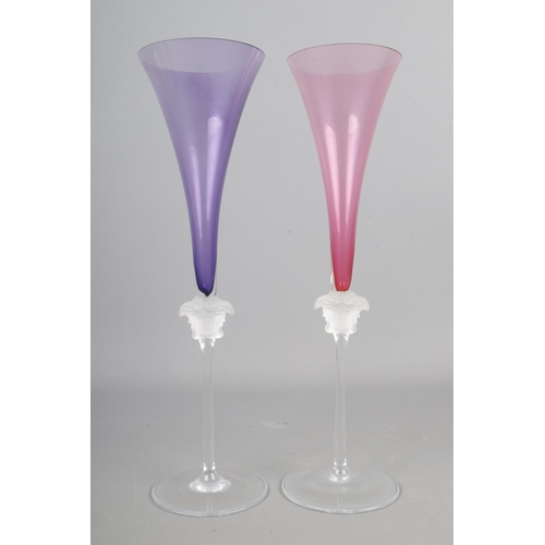 609 - Two Rosenthal Versace Medusa head champagne glasses, with purple and pink flutes. Height: 30cm.