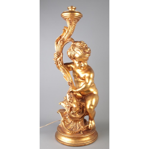 83 - A large gilt lamp formed as a seated putto. Height 72cm.