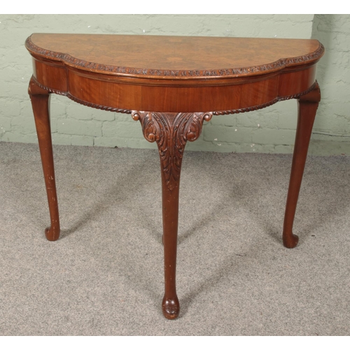 622 - A walnut fold over side/games table. Raised on carved cabriole supports.