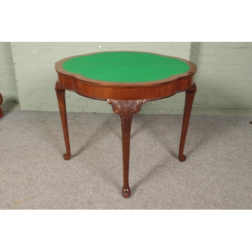 622 - A walnut fold over side/games table. Raised on carved cabriole supports.