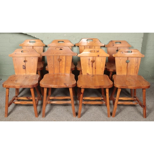 641 - A set of eight pine dining chairs. With heart shaped carved decoration to the backs.