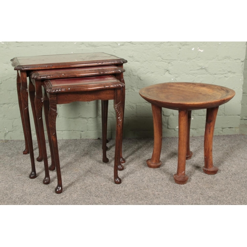 646 - A carved African hardwood stool with dish top, along with a nest of three mahogany tables.