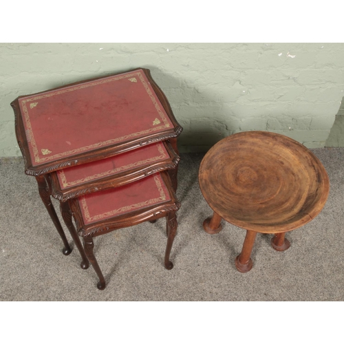 646 - A carved African hardwood stool with dish top, along with a nest of three mahogany tables.