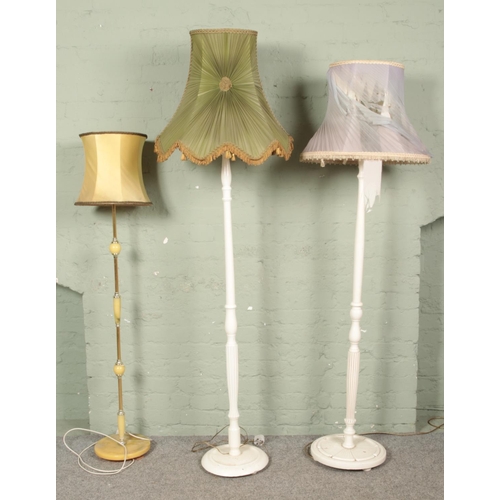 658 - Three standard lamps. Includes two white painted examples and a faux marble example.