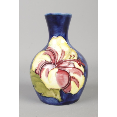 90 - A petite Moorcroft bud vase, in the Hibiscus pattern. Height: 9cm.