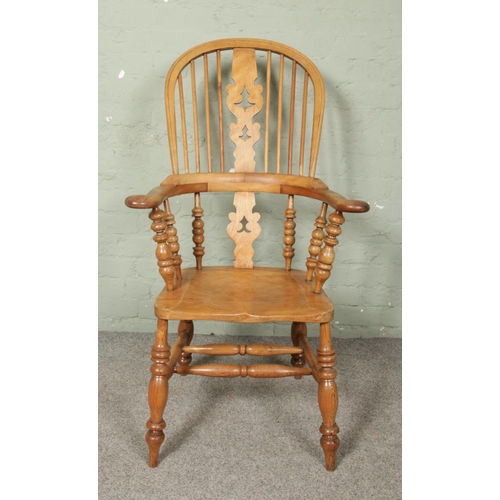 666 - An ash/elm Windsor pad arm chair. Having bobbin turned arm supports.