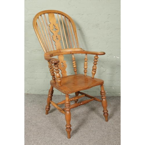 666 - An ash/elm Windsor pad arm chair. Having bobbin turned arm supports.