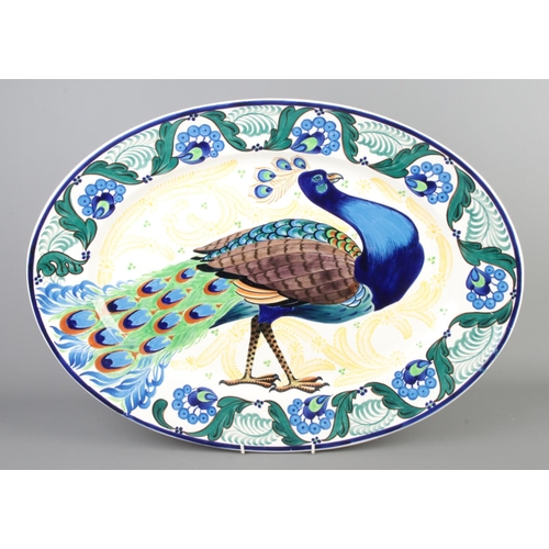 92 - A large hand painted oval platter/meat plate decorated with a peacock. Marked to the back Copenhagen... 