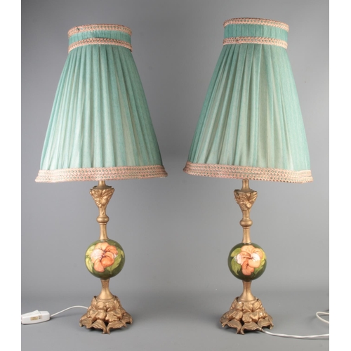 96 - A pair of Moorcroft pottery and gilt metal Hibiscus pattern lamps.