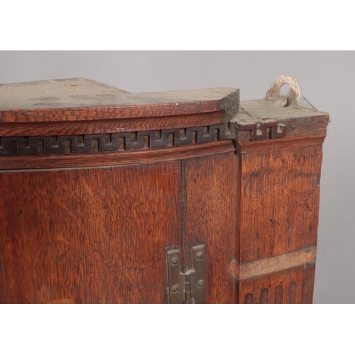 451 - A Georgian oak bow front corner cupboard. Height 99cm.