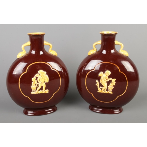 83 - A pair of brown glazed moon flask vases with Pate-Sur-Pate decoration depicting cherubs, with mustar... 