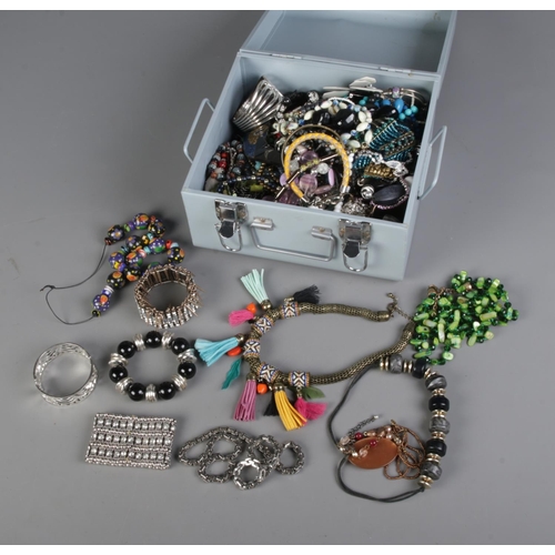 113 - A tin of assorted costume jewellery to include beaded necklaces, bracelets, mother of pearl, etc.