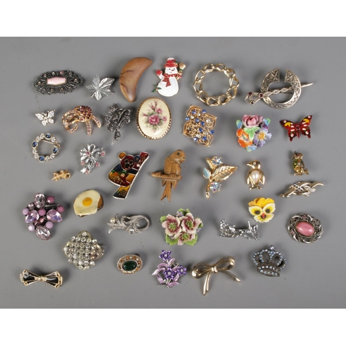 114 - A collection of assorted costume jewellery brooches to include floral, animal and food examples.