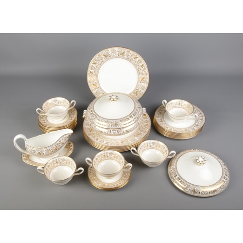 13 - A Wedgwood Gold Florentine (W4219) dinner service to include lidded tureen, breakfast cups, dinner p... 