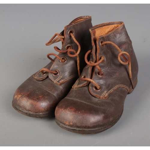 141 - A pair of vintage children's boots. One bearing label to sole for CWS Derby.