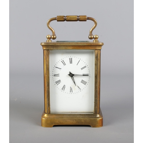 2 - Gilt brass cased carriage clock,  loop handle with bevelled edge glass panels, open escapement and w... 