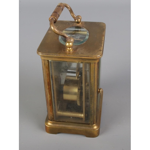 2 - Gilt brass cased carriage clock,  loop handle with bevelled edge glass panels, open escapement and w... 