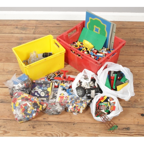 173 - Two boxes of Lego. Includes figures, bricks, wheels, platforms etc.