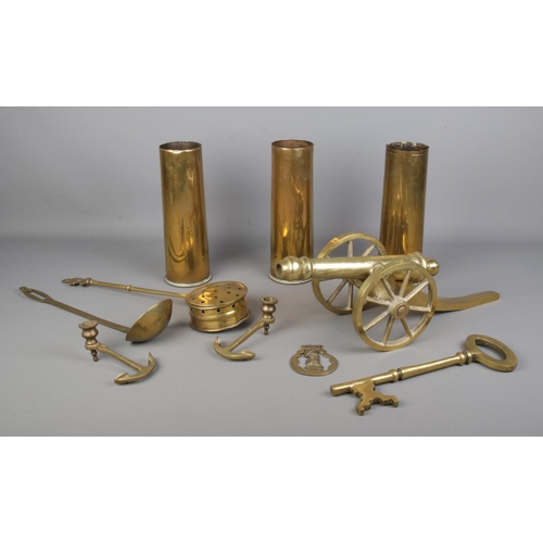 29 - A collection of brasswares, to include heavy desk cannon, large key, a pair of anchor candle snuffer... 