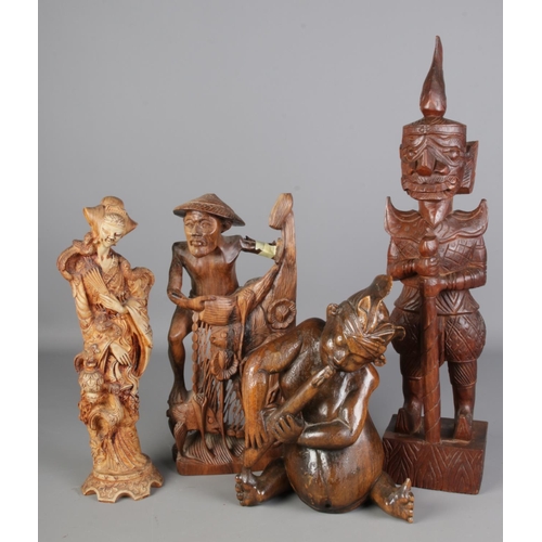 148 - A collection of eastern carved wooden figures including one composite example