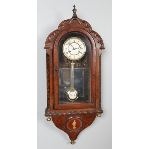 331 - A mahogany and walnut cased wall clock, with carved top and 'Greek Key' column detailing. Features R... 