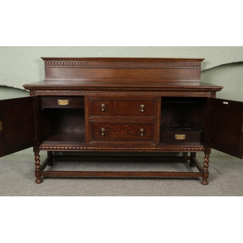 443 - A substantial oak carved sideboard/server with barley twist supports, half turned mounts and brass d... 