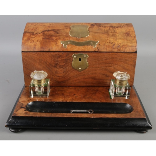 11 - An early 20th century walnut and ebonised desk tidy with ink well and brass plaque to centre, includ... 