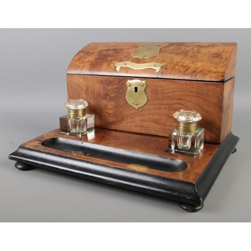 11 - An early 20th century walnut and ebonised desk tidy with ink well and brass plaque to centre, includ... 